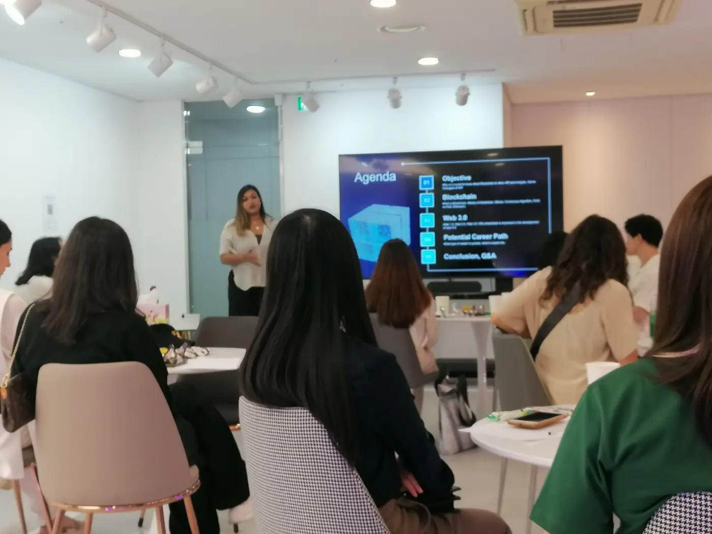 A woman doing a presentation about Blockchain and web3 to a young audience